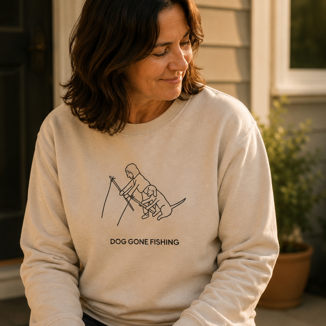 The MoreWoof Dog Gone Fishing sweatshirt showing a person fishing with their dog