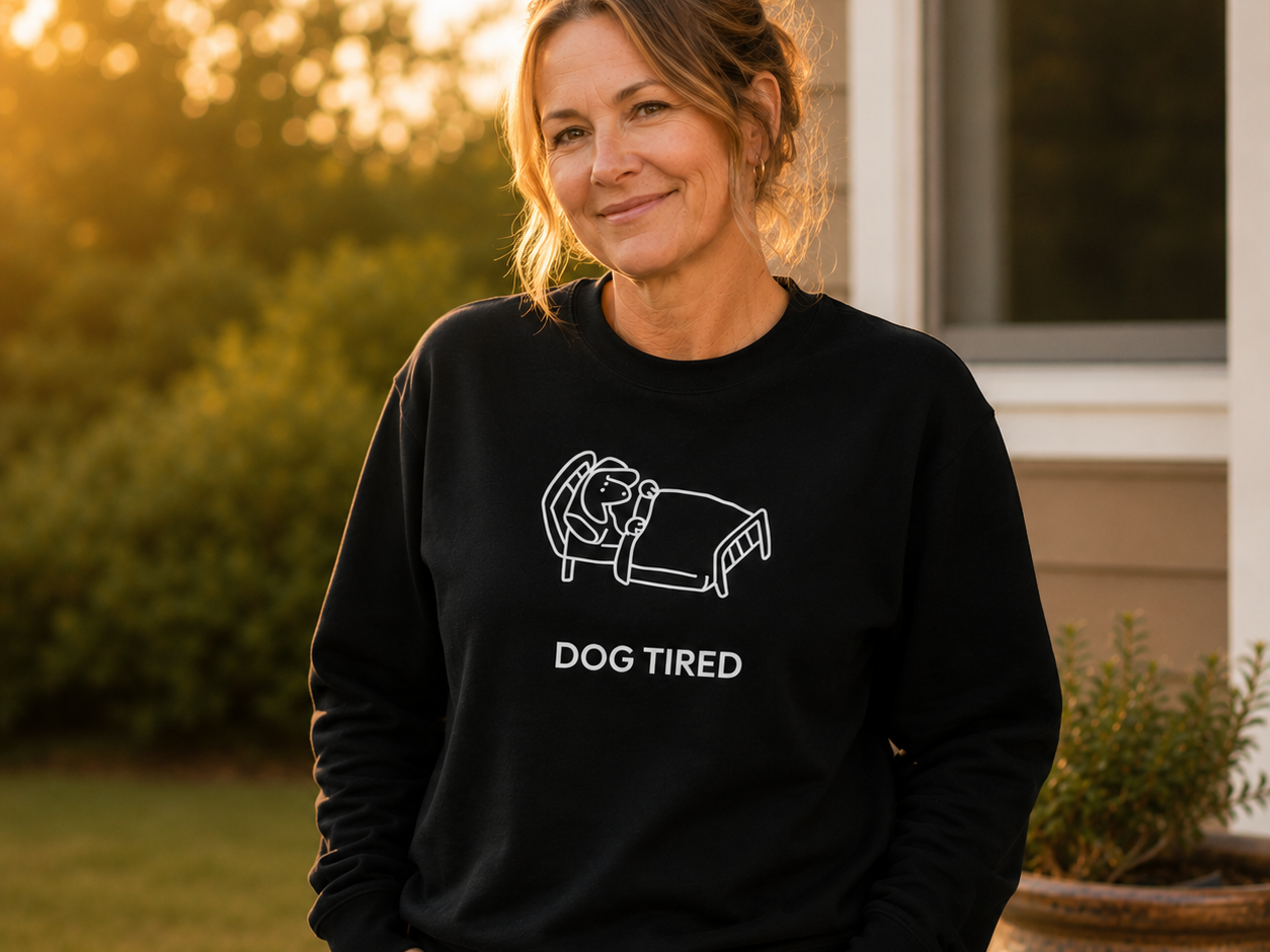 Dog Tired sweatshirt featuring a dog lying on a daybed beside its owner